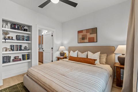 A bedroom with a large bed and a ceiling fan.