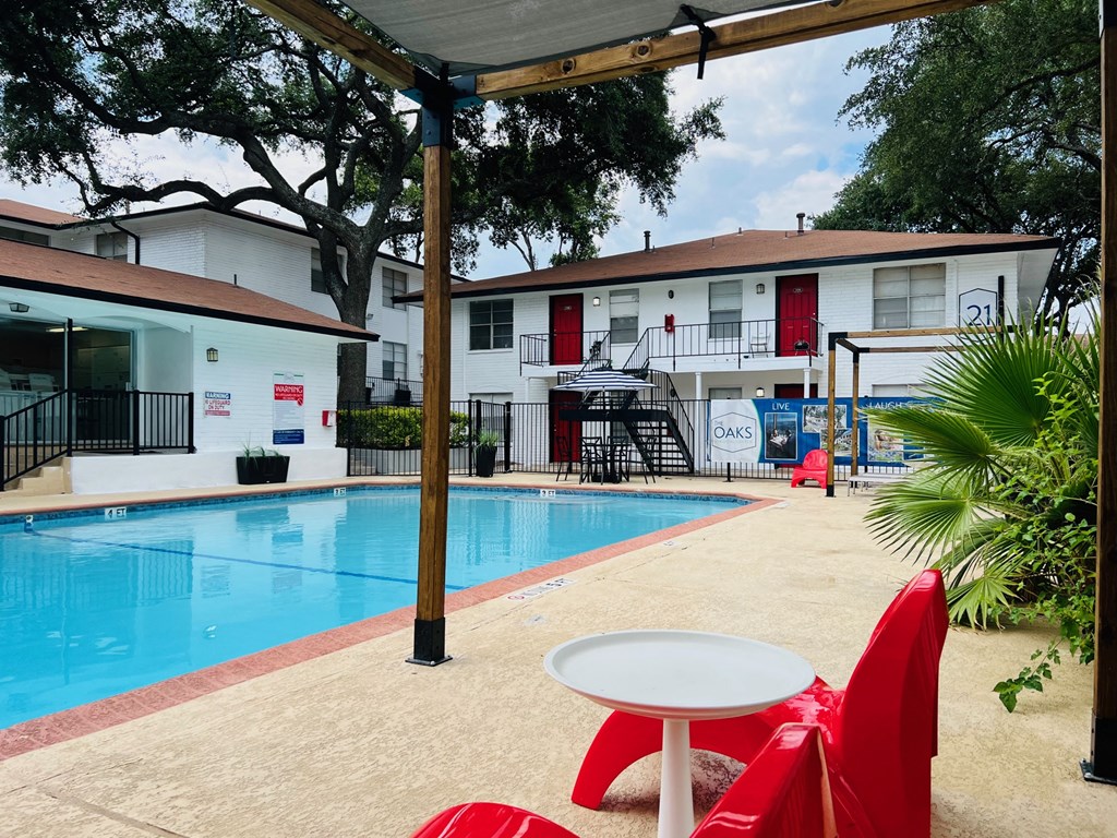 a swimming pool with a table and chairs next to a pool