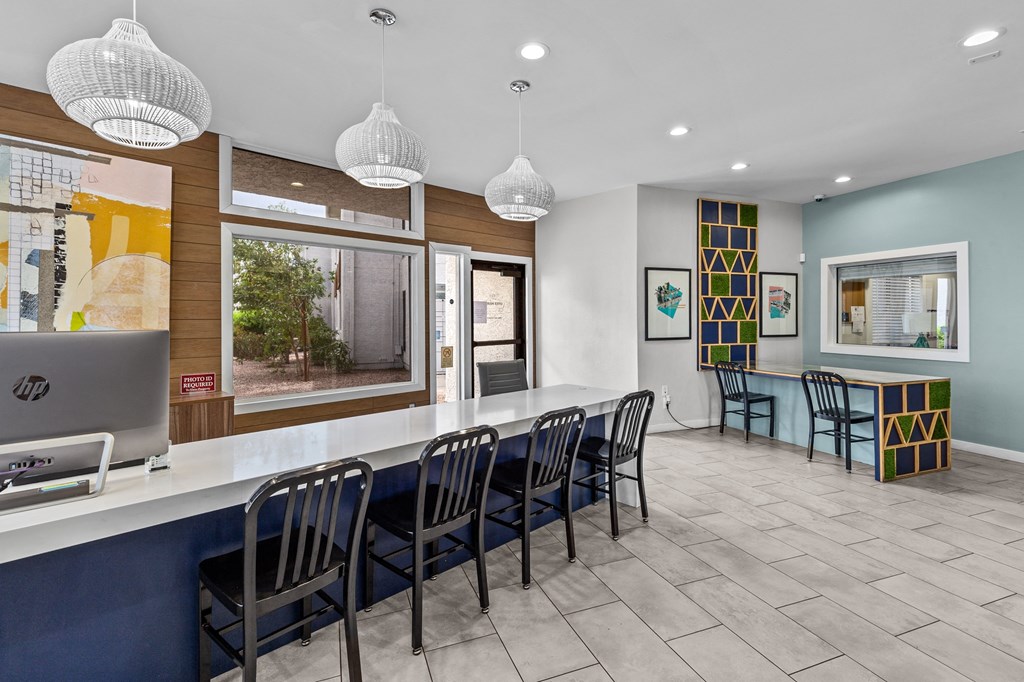 a seating area with a counter and chairs in front of a window