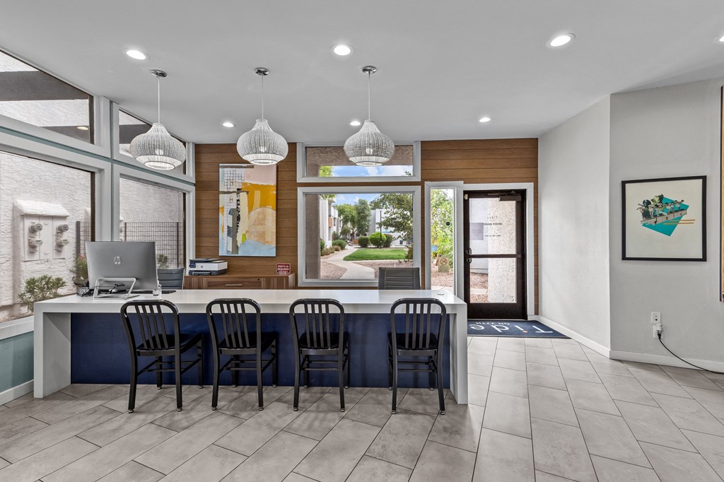 a kitchen with a long island with a computer on it and a large window with a view