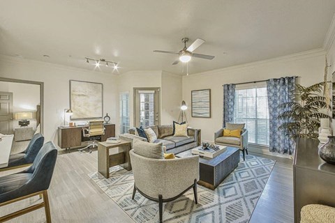 a living room filled with furniture and a ceiling fan