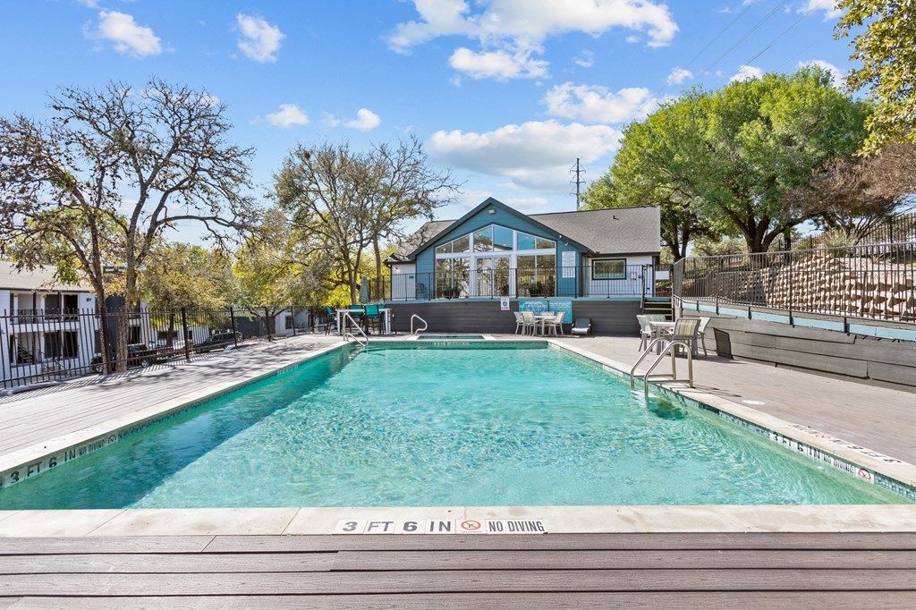 a swimming pool with a house in the background