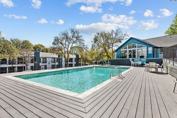 A wooden deck surrounds a rectangular pool.