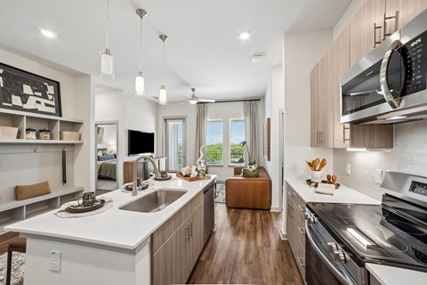 A modern kitchen with a white countertop and stainless steel appliances.