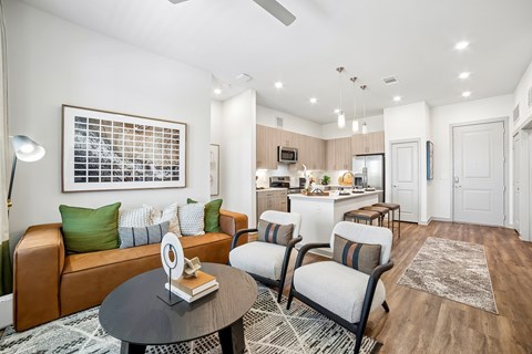 A modern living room with a brown leather couch and a coffee table in the center.