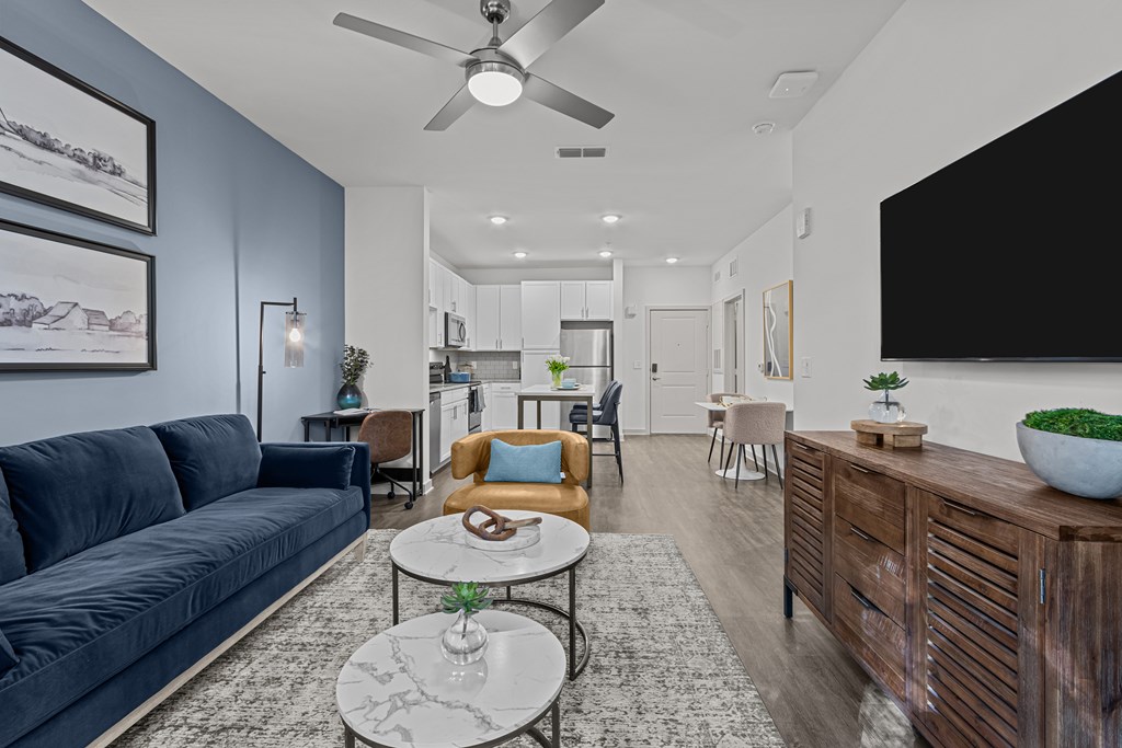 A modern living room with a dark blue sofa and a wooden cabinet.