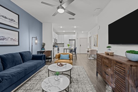 A modern living room with a dark blue sofa and a wooden cabinet.