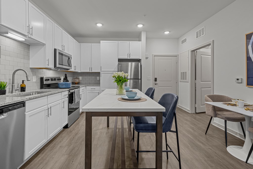 A modern kitchen with a dining table and chairs.