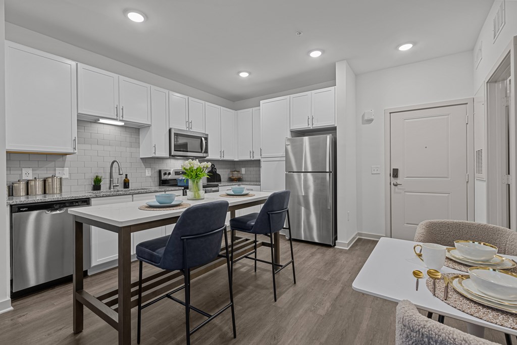 A modern kitchen with a dining table and chairs.