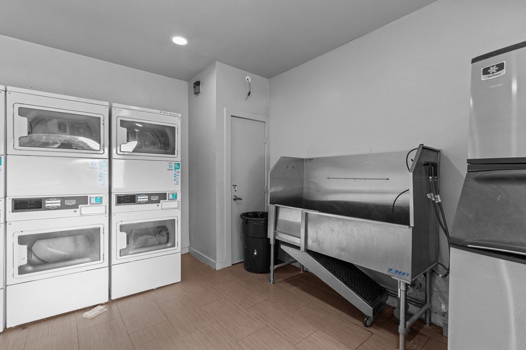 a kitchen with appliances and a bed and a refrigerator