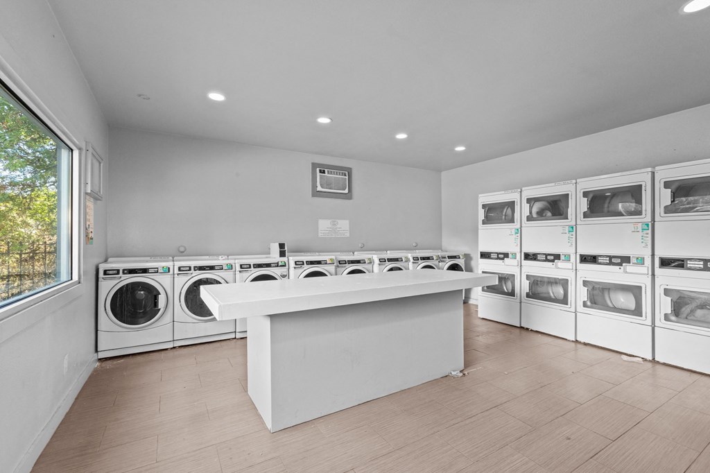 a laundry room with a counter and washes and dryers in it