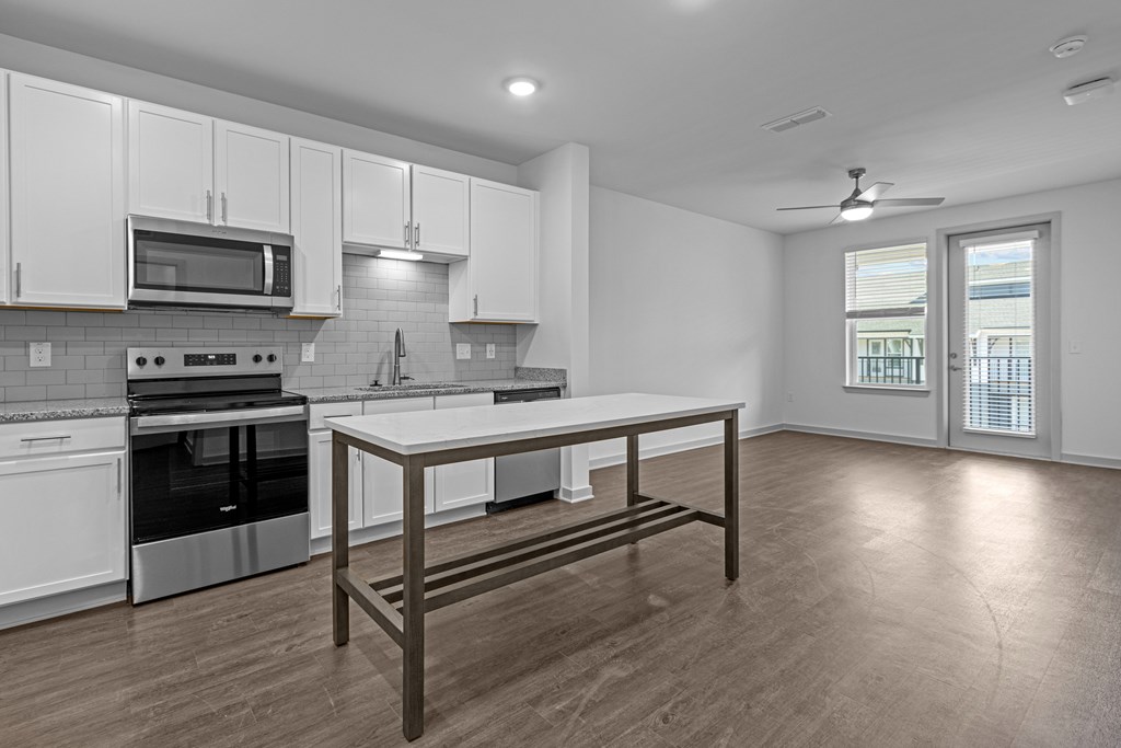 A modern kitchen with a table and stainless steel appliances.