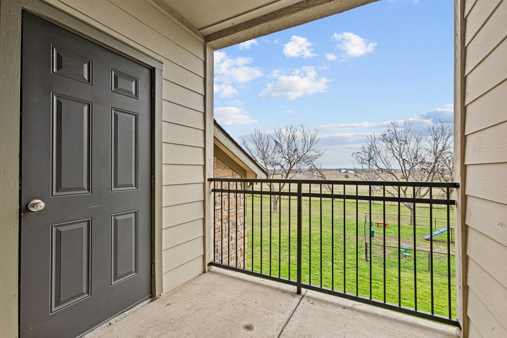 A view from a doorway looking out to a fenced yard.