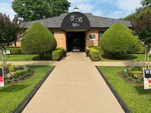 a brick building with a black awning and a sidewalk in front of it