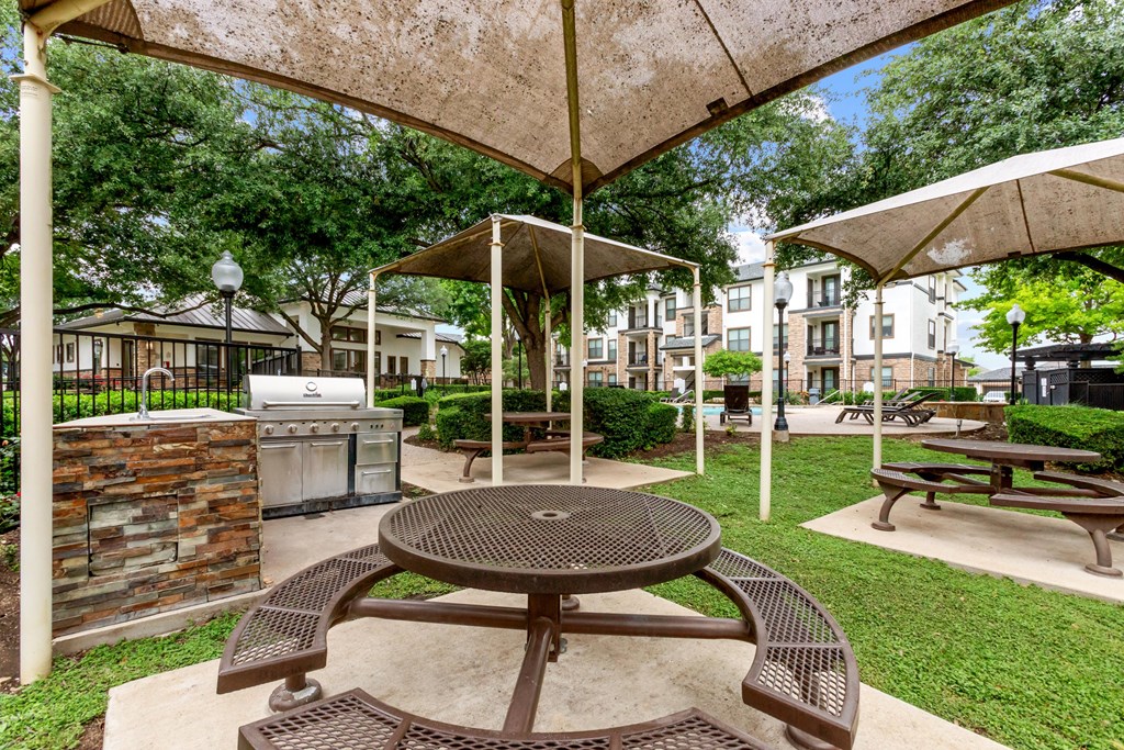 A patio with a table and chairs under a canopy.