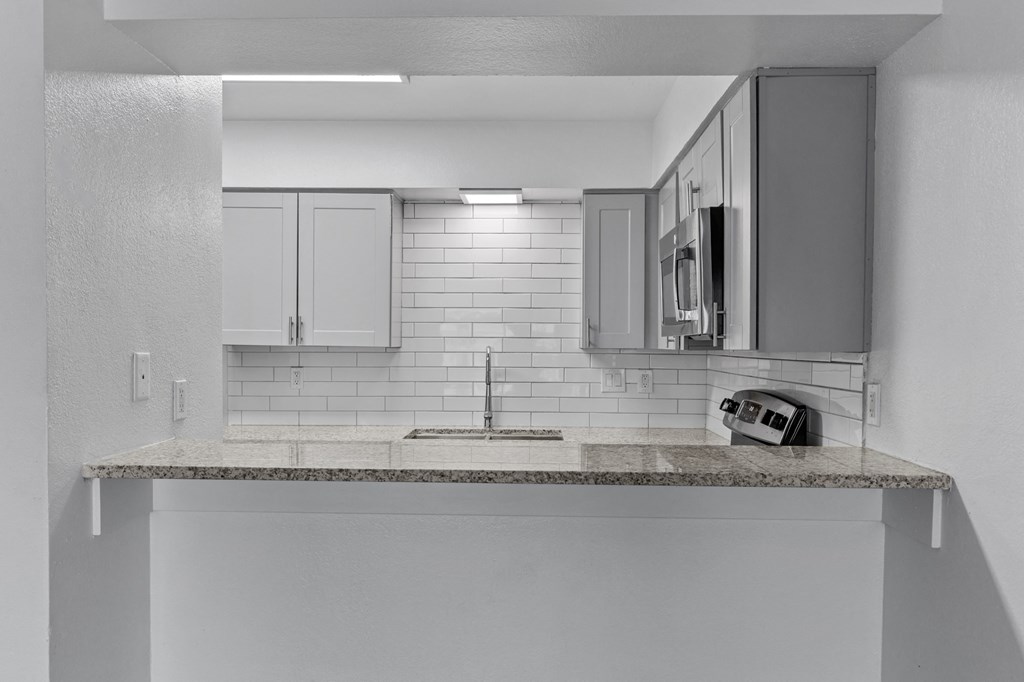 a kitchen with white cabinets and a sink and a telephone