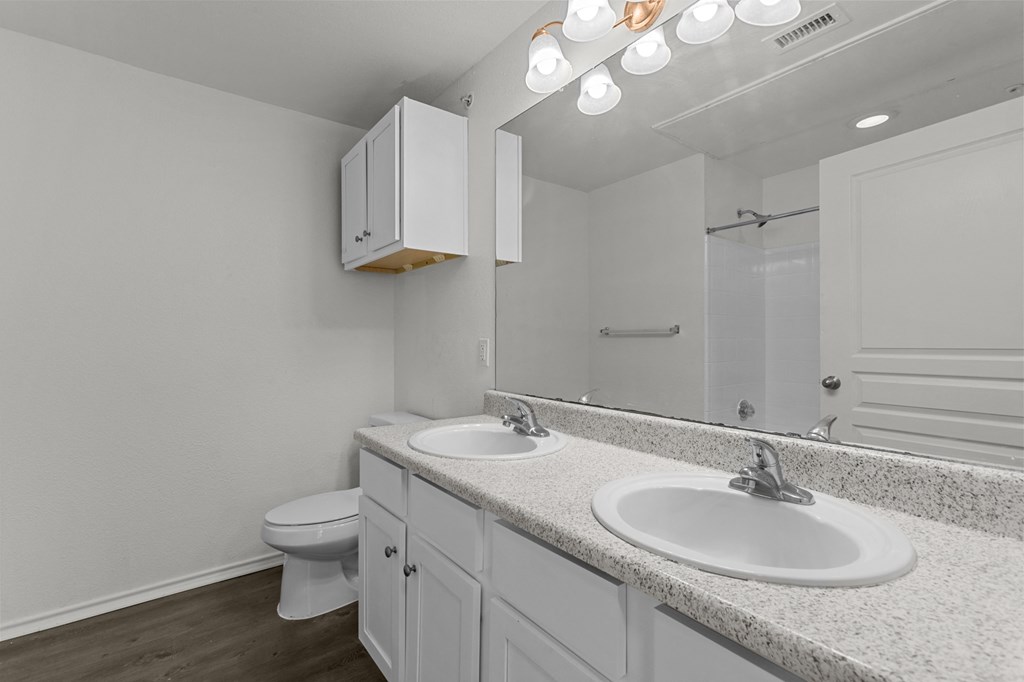 A white bathroom with a toilet, sink, and medicine cabinet.