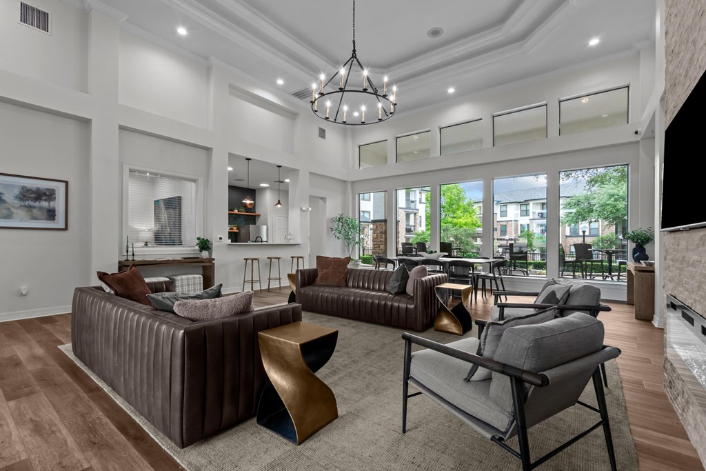 A modern living room with a brown sofa and a grey armchair.