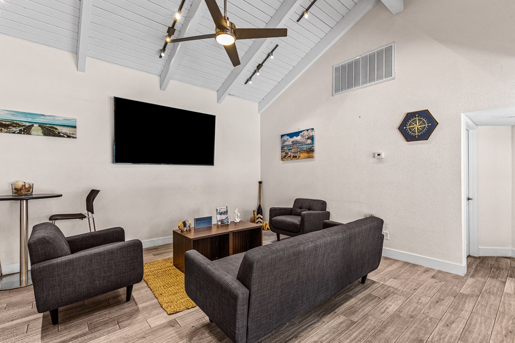 a living room with couches and chairs and a tv