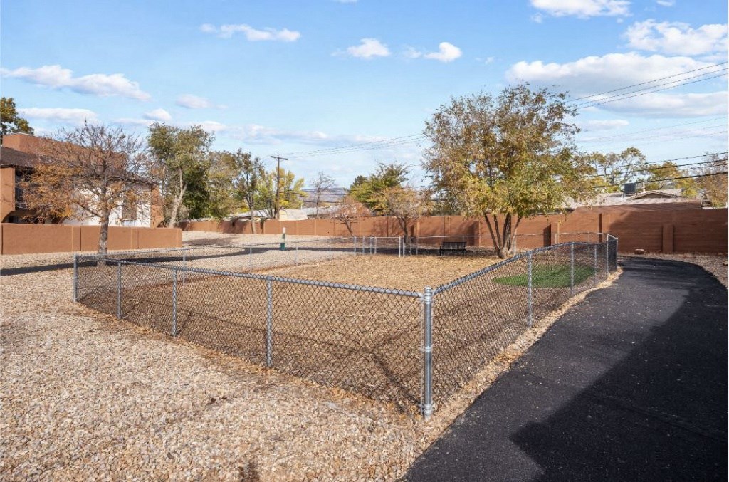 a fenced in dog park with a chain link fence