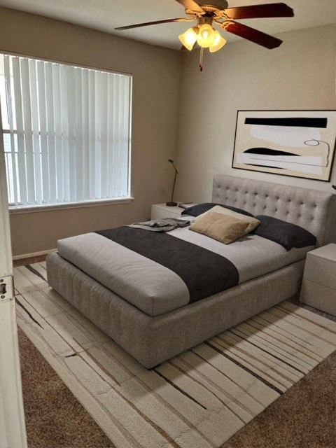 a bedroom with a bed and a ceiling fan