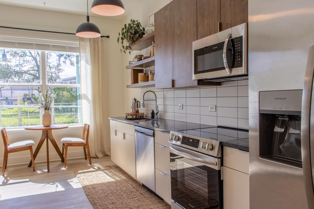 A modern kitchen with stainless steel appliances and wooden cabinets.