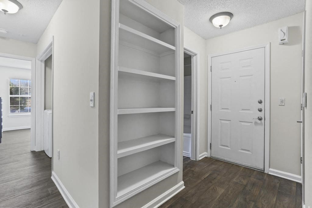a white room with shelves and a door
