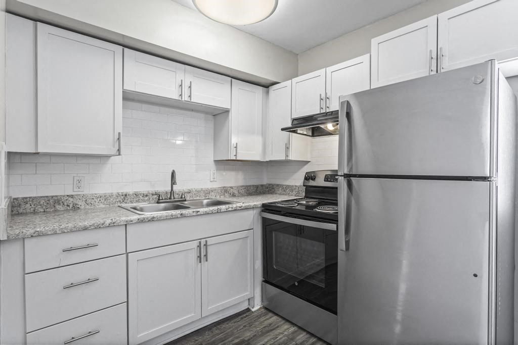 a kitchen with white cabinets and a stainless steel refrigerator
