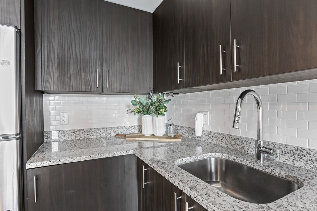 A kitchen with a sink and a refrigerator.