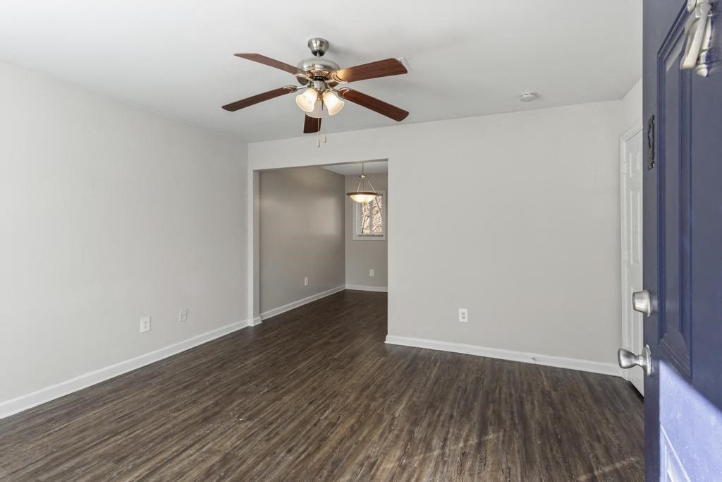 an empty living room with a ceiling fan