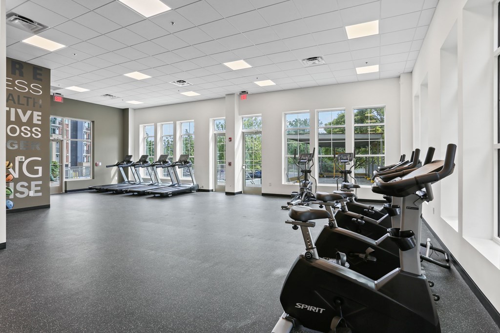 A gym with a row of stationary bikes and a sign that says "Fitness is a journey, not a destination".