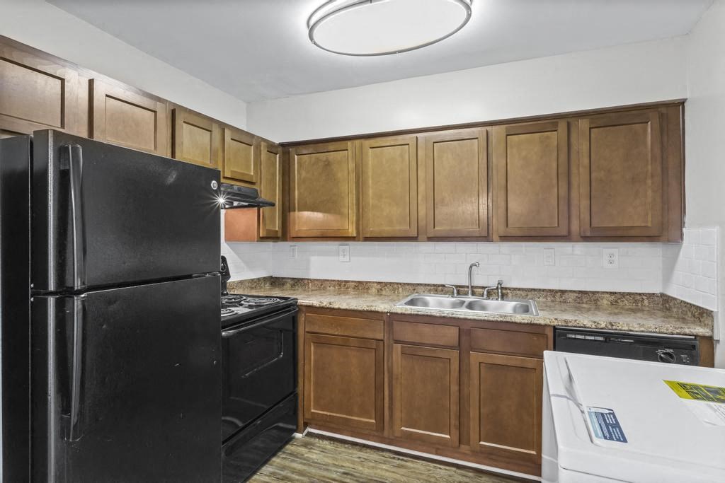 a kitchen with black appliances and wooden cabinets