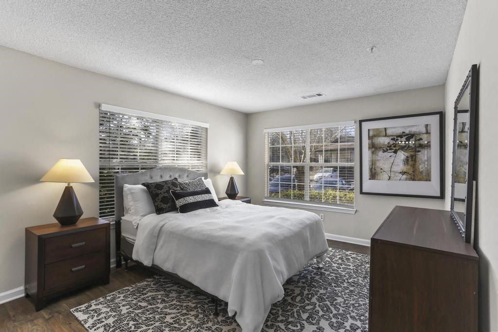 a bedroom with a bed and two windows