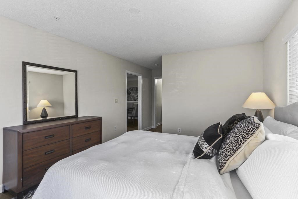 a bedroom with a large bed and a mirror