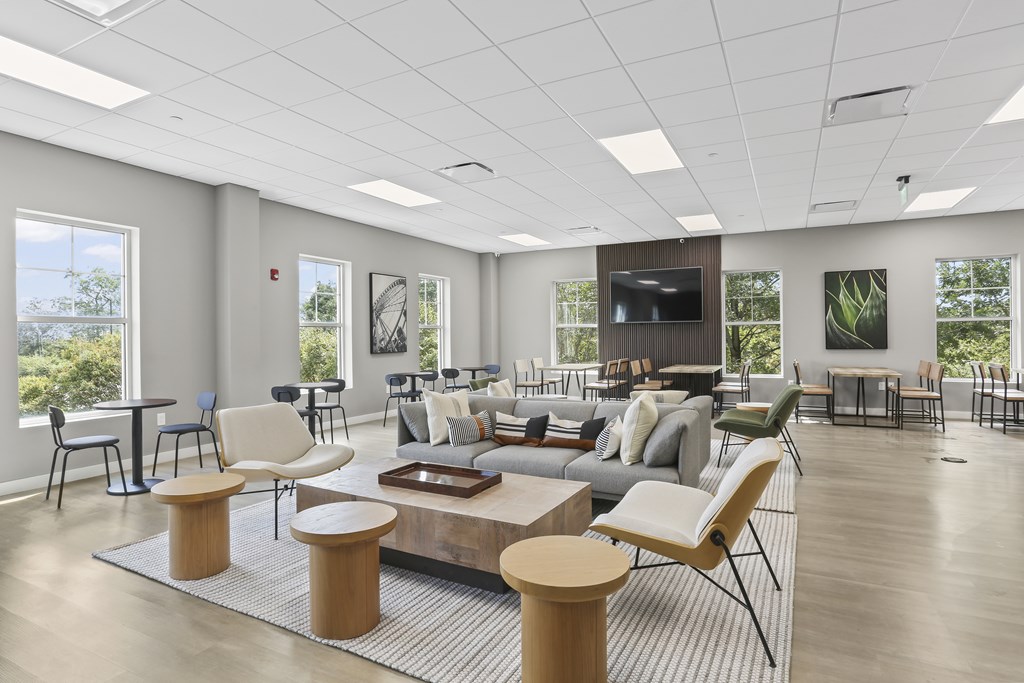 A spacious living room with a grey sofa set and a television.