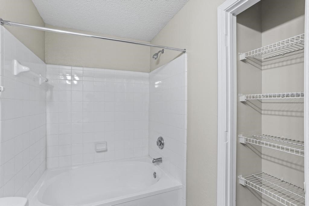 a white bathroom with a shower and a sink
