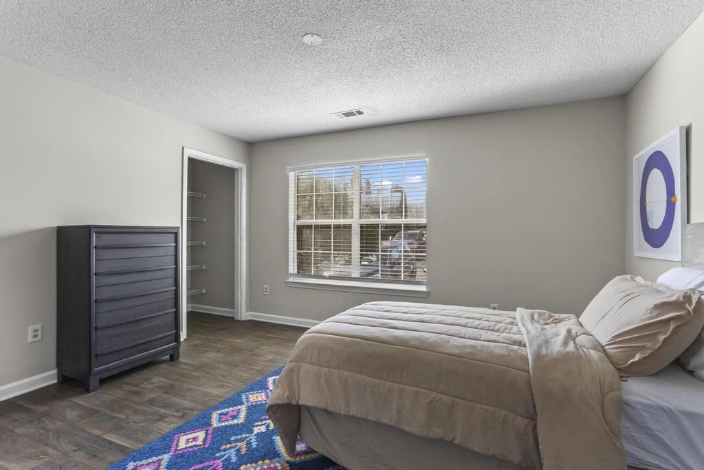 a bedroom with a bed and a dresser and a window