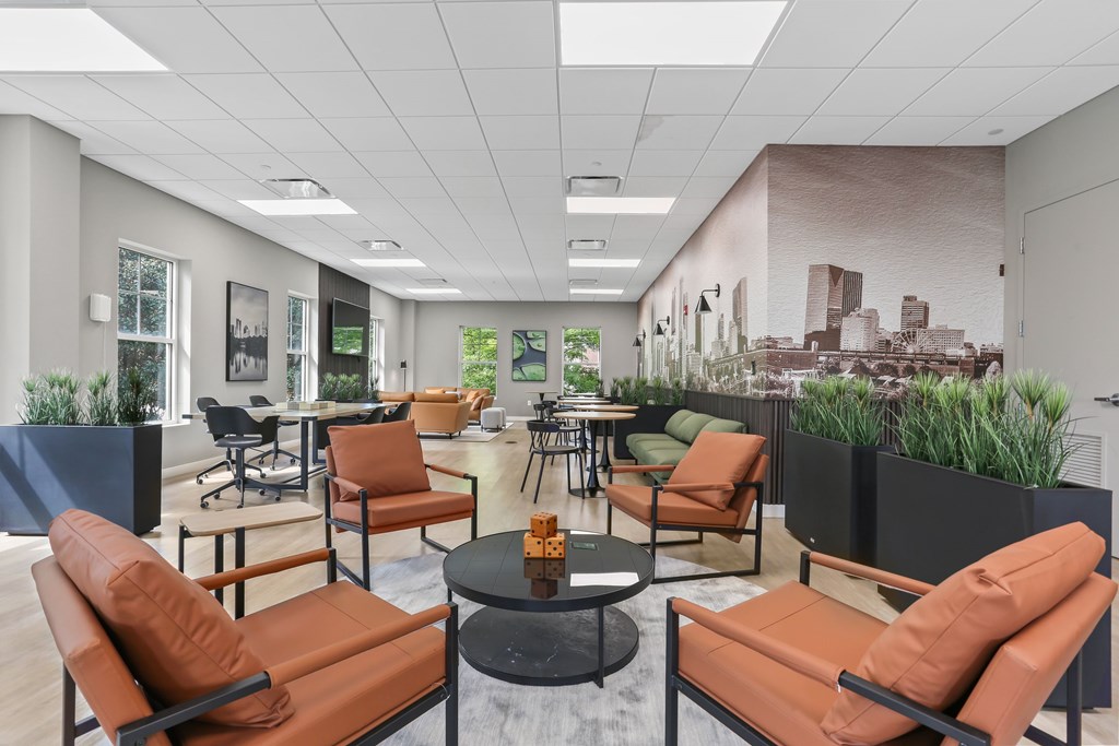A modern office space with orange chairs and a cityscape mural on the wall.