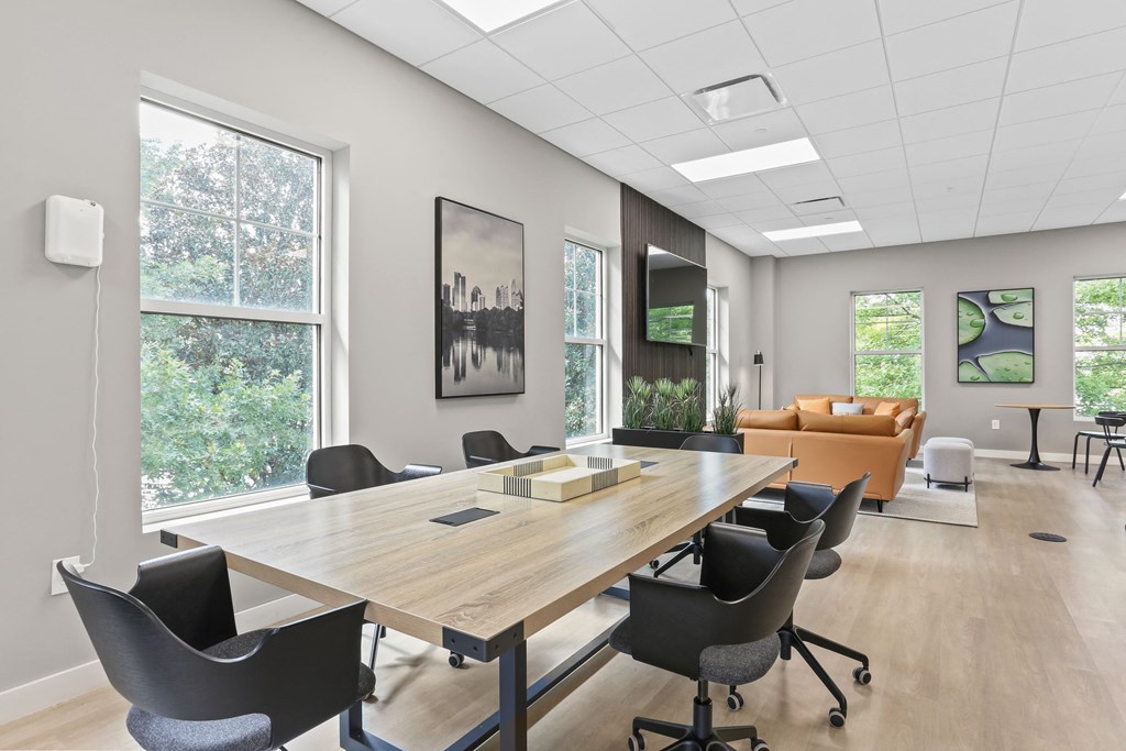 a conference room with a wooden table and black chairs