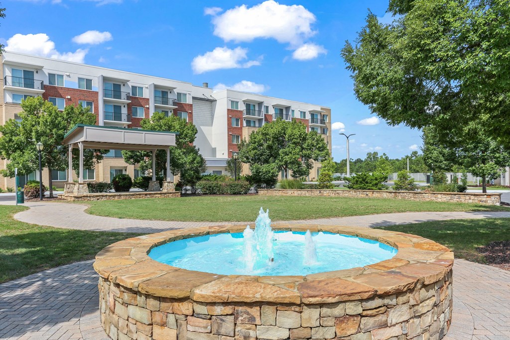 A fountain in the middle of a brick patio.