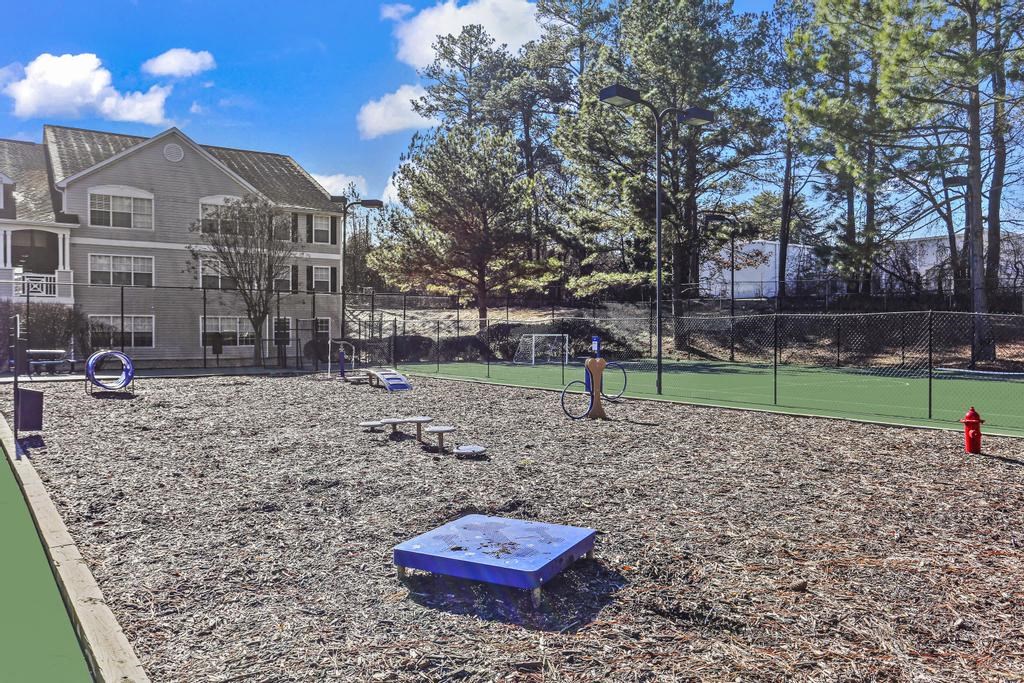 a backyard with a playground and a tennis court     and a house