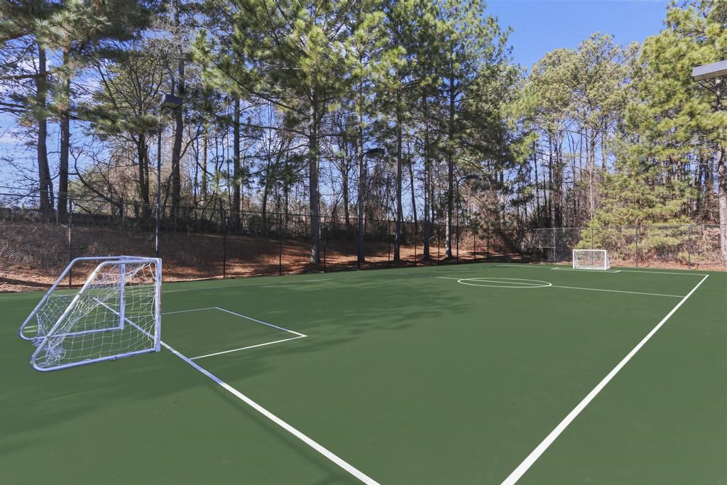a tennis court with a soccer goal on it