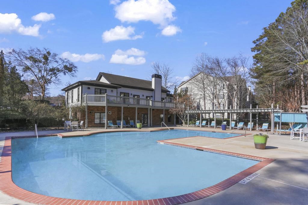 a large swimming pool with a house in the background