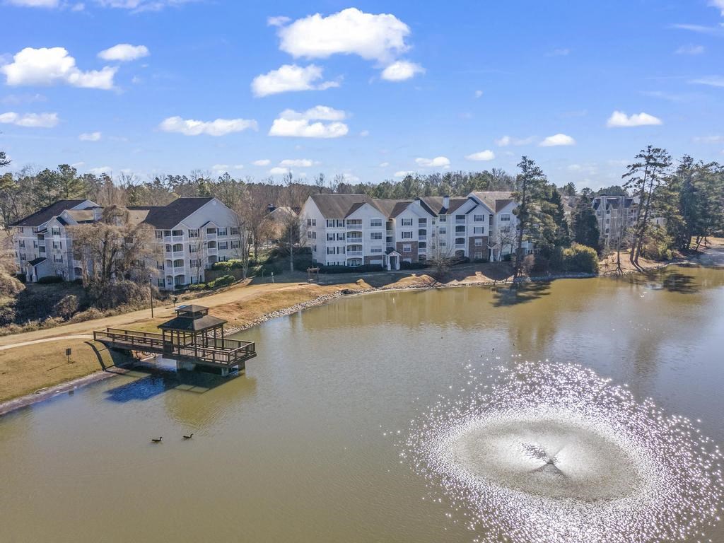 an aerial view of a lake with buildings in the background