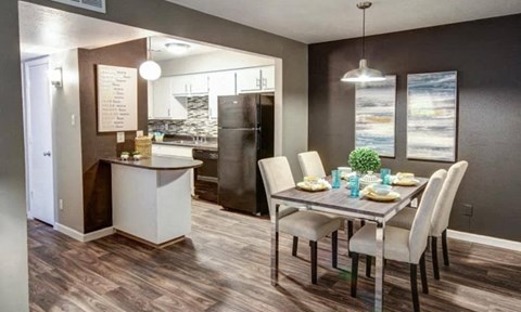 a dining room and kitchen with a table and chairs