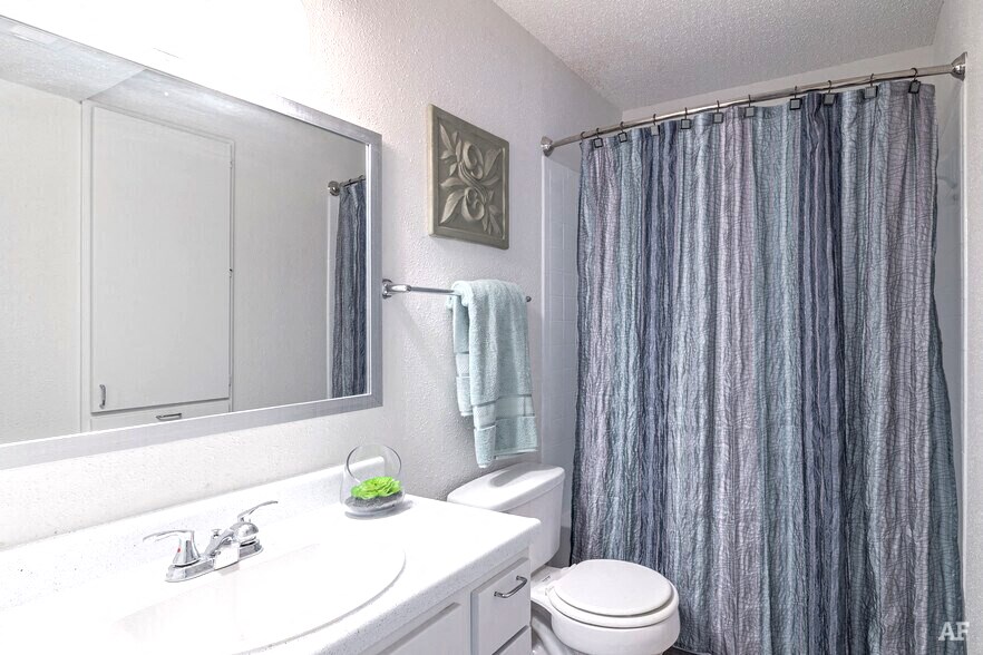 a white bathroom with a shower curtain and a sink