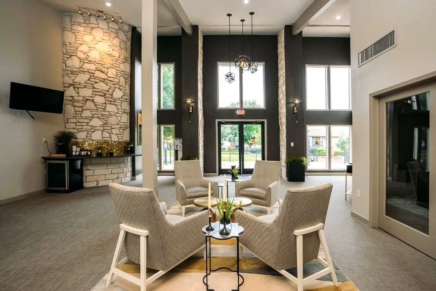 a living room with couches and chairs and a stone fireplace