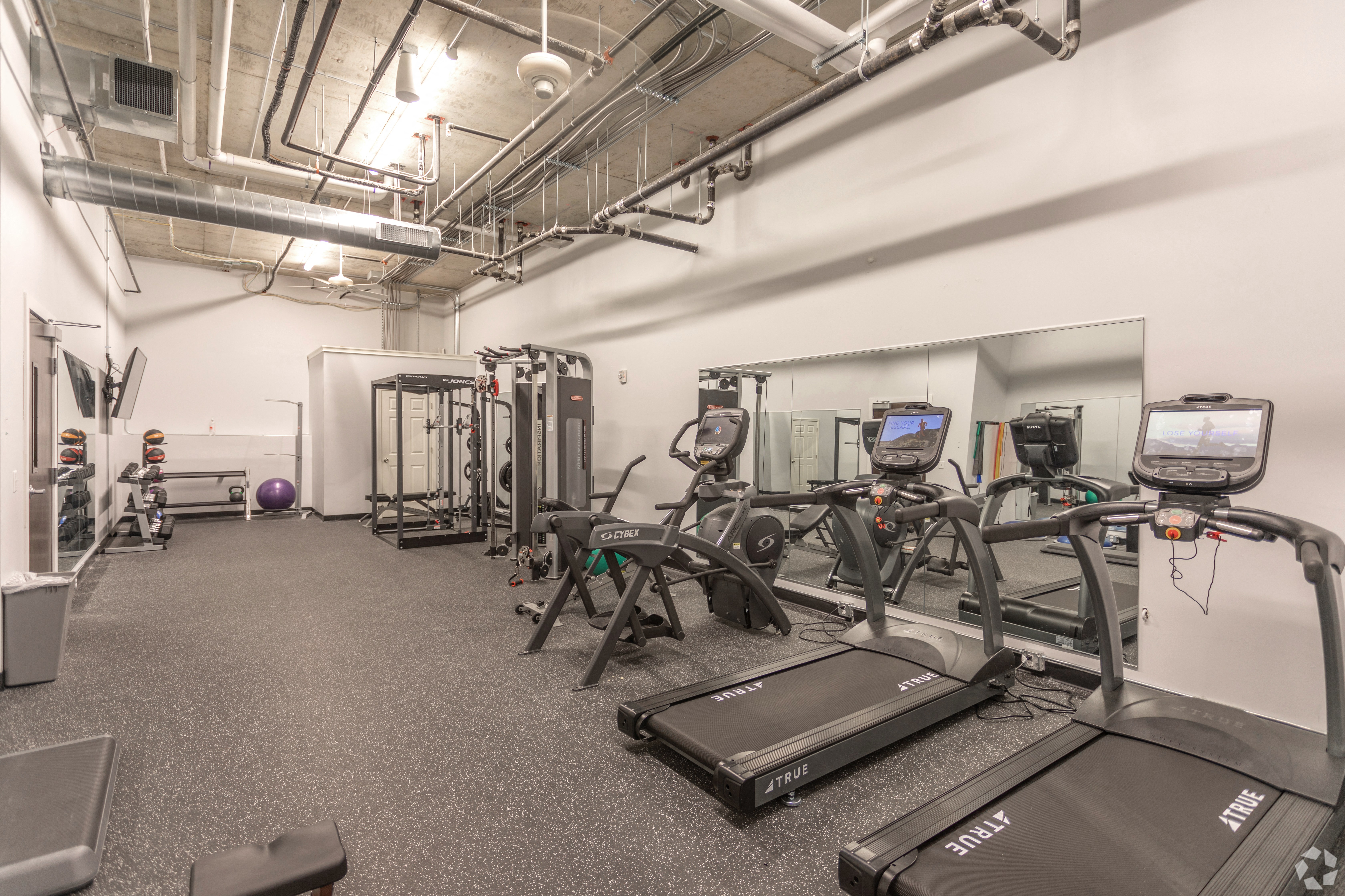 a large fitness room with treadmills and other exercise equipment