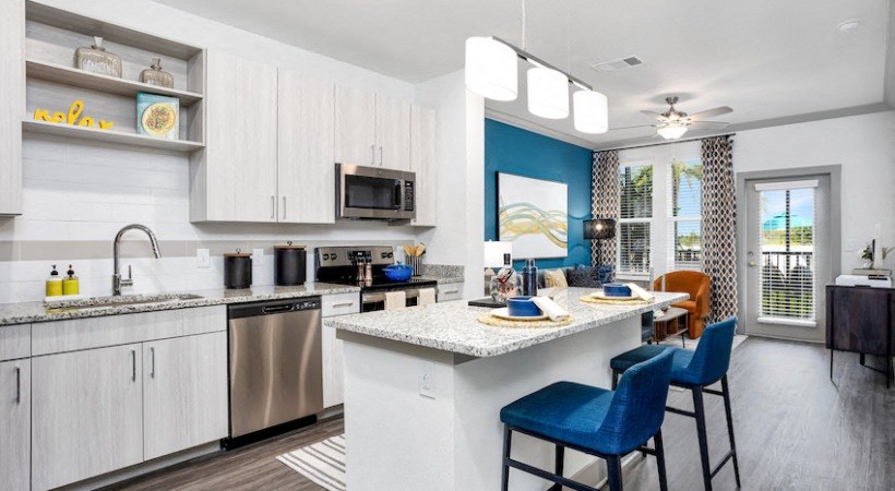 A kitchen with a white countertop and blue chairs.