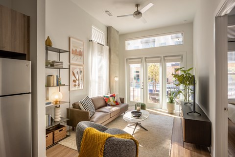 A modern living room with a grey sofa and a yellow throw.